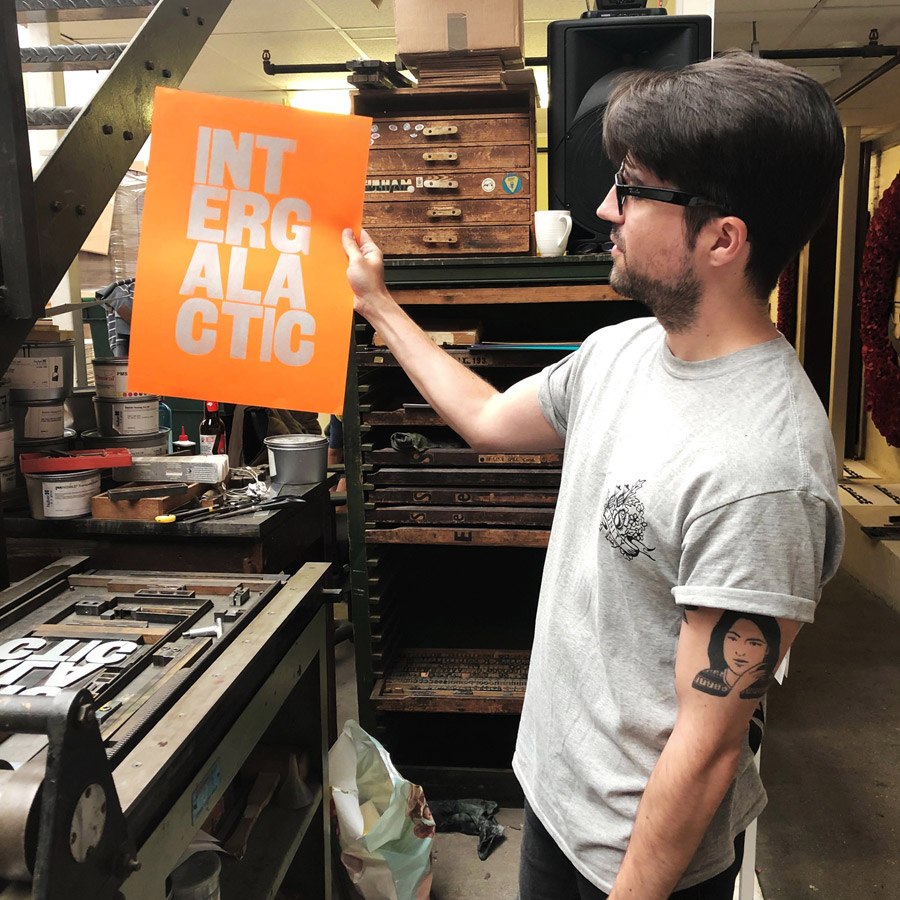 Man with screen printed poster he has just made