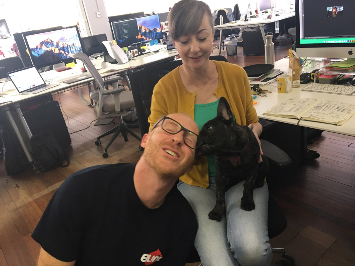 Man and woman in an office with a small dog